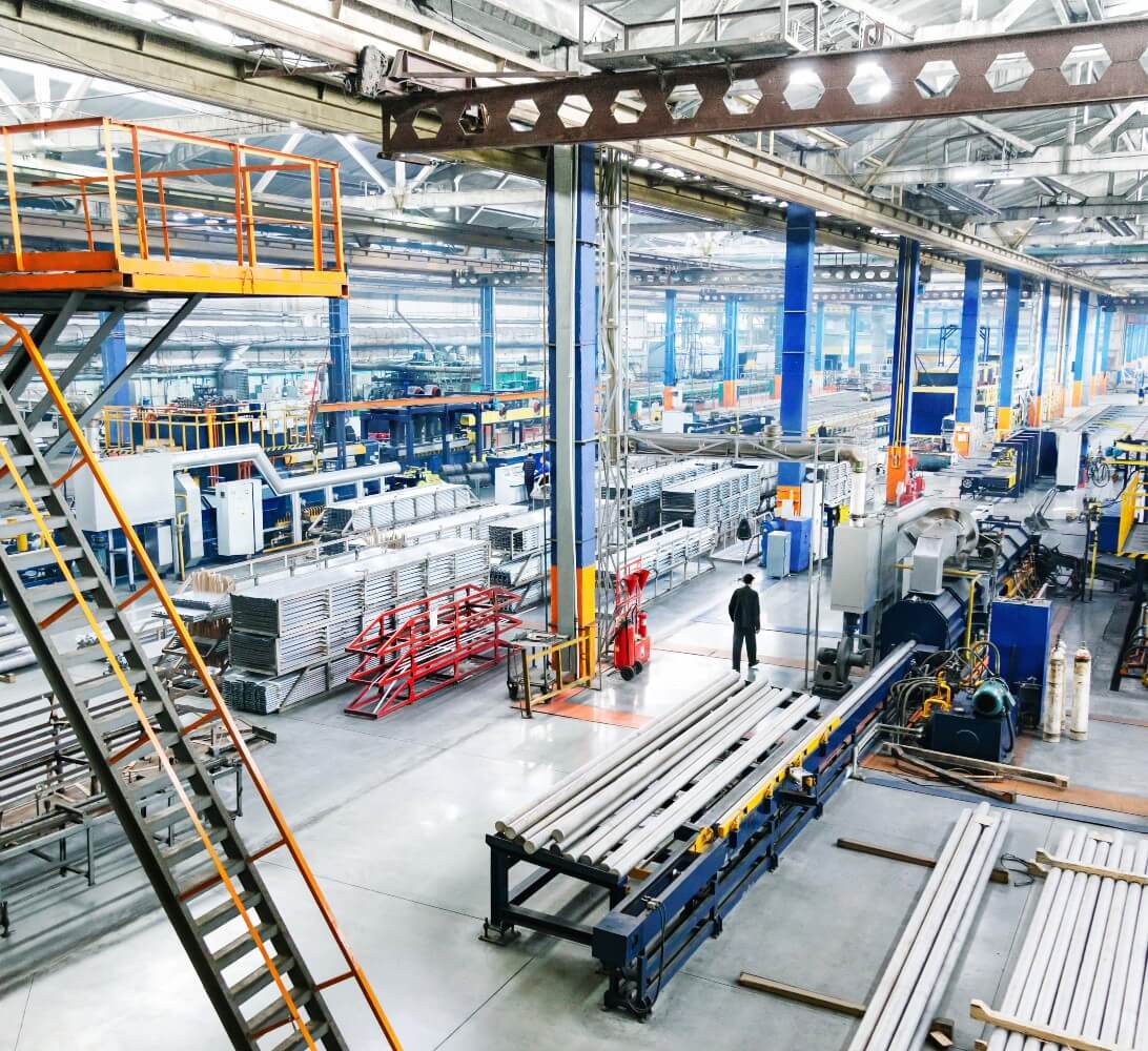 Inside of steel manufacturing warehouse with tall shelves and machinery