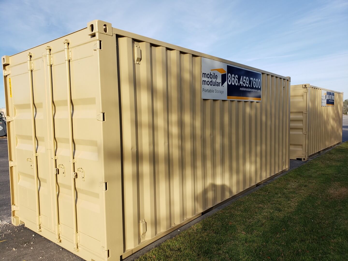 A shipping container in mid-air operated by a man in a forklift