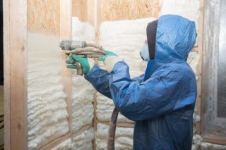 Applying spray foam insulation to a container