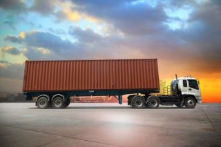 A flat-bed trailer carrying container.jpg