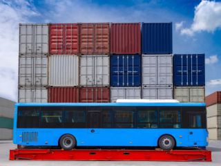 Loading a bus for export on a rack container flat.jpg