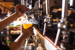 bartender pours beer into a glass.jpg